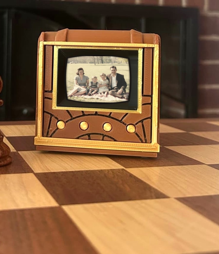Pict-O-Vision miniature television on a chess board, its 2-inch screen showing a family photograph